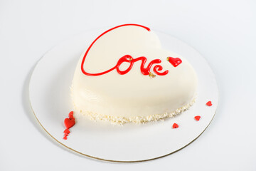 .A cake in heart shape.  Mousse light cake in the shape of a heart with the inscription love on a gray background. Sweet Valentine. Valentine's Day