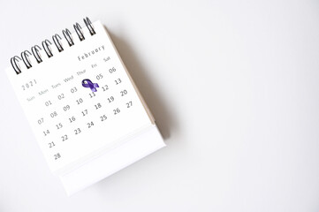Purple ribbon on calendar February 4 concept World Cancer Day