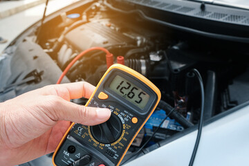 Mechanic hand use multimeter voltmeter to check the voltage level
