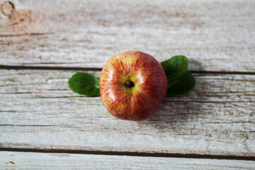 Large red apples lie on a wooden table