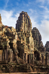 Fototapeta na wymiar Sunrise on a face tower in the Bayon temple in Angkor Thom, Angkor. Cambodia. Vertical view.