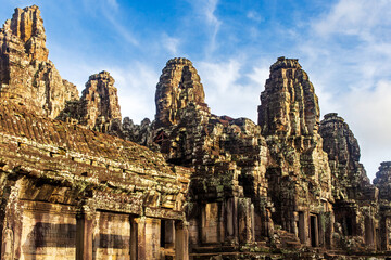 Sunrise on some of the face towers in the Bayon temple in Angkor Thom, Angkor. Cambodia. Vertical...