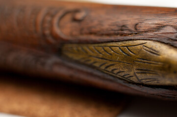 Close up detail of an engraved pattern on an old wooden pistol