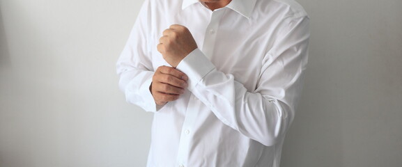 A handsome man in his loft dresses his sexy white shirt
