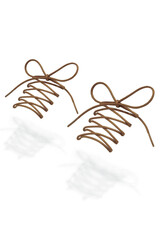 Fototapeta premium Subject shot of beige shoe strings with thin tips. The plaited shoe laces are tied in a bow and hanging in the air on the white background. 
