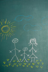 Drawing of a happy familly (father, mother, son) on a blackboard