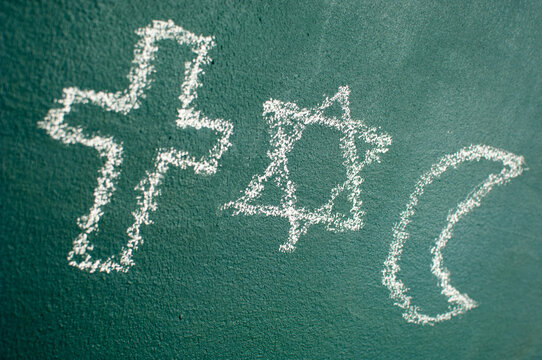 Star of David, Cross and Islamic Crescent on a blackboard