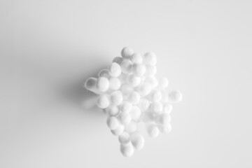 Close-up photo of white cotton swabs and white cotton swabs on isolated white background.
