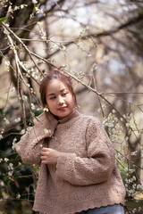 Portrait of Asian young woman enjoying plum blossom garden in the spring.