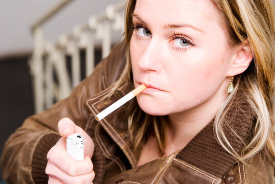 junge Frau mit Zigarette und Blick in die Kamera