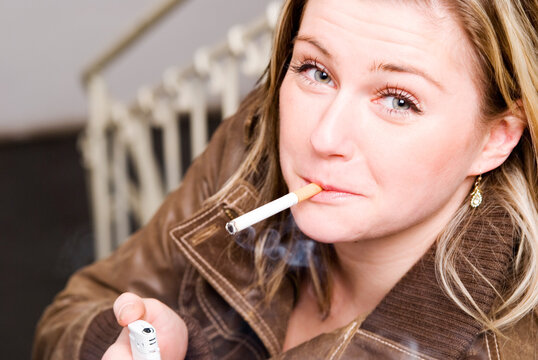 Junge Frau beim anzünden einer Zigarette