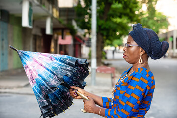 beautiful adult businesswoman opening her umbrella in the street