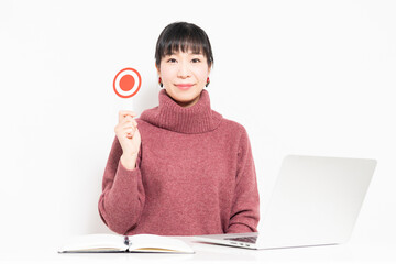 パソコンを使いながらOKのプラカードを持つ女性