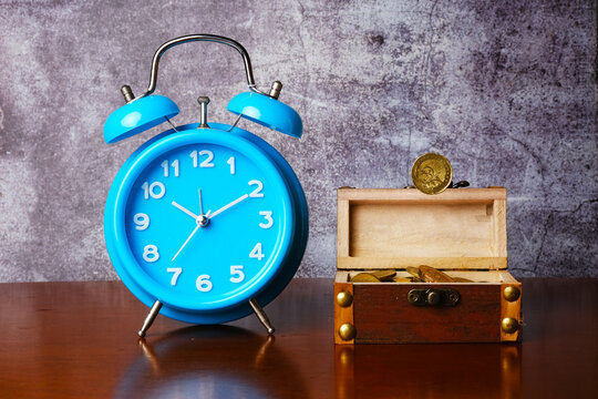 A picture of levitation money with gold chest open and alarm clock for time value of money concept.