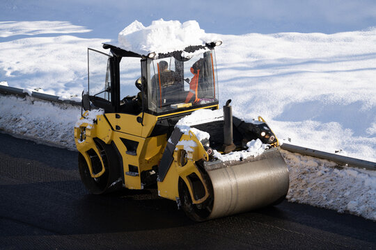 Winter repair work on the mountains. Heavy cars are laying asphalt