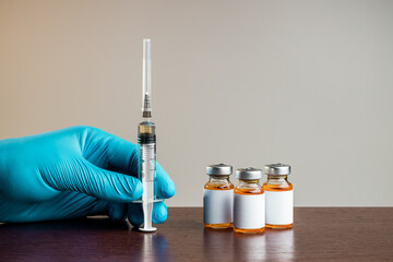 medical person preparing to injection of medical vaccine or treatment. blank vials. copy space....