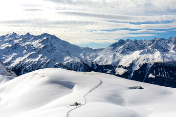 Fototapeta na wymiar Single ski mountaineering tracks on a white snow-covered plateau in winter above Verbier in Switzerland.