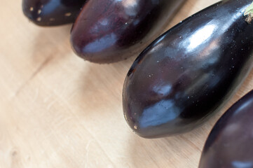 Purple eggplants or aubergine on wooden background