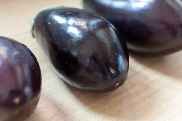 Purple eggplants or aubergine on wooden background