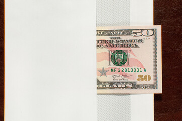 One banknote of fifty US dollars in an white envelope