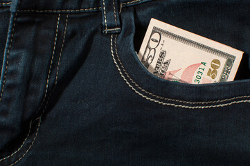 One banknote of fifty US dollars in the pocket of jeans