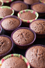 Homemade chocolate cupcakes in a colorful paper container ready for frosting