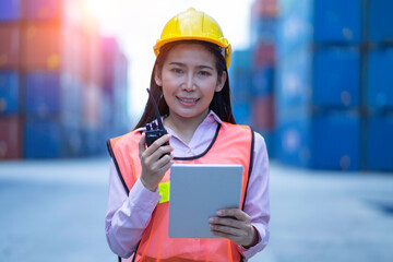 Logistics Concept , Foreman uses a laptop to control the loading of containers from shipping vessels to export around the world.