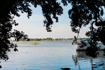 Żegluga jachtem na jeziorze na Mazurach, odpoczynek w przycumowanym do brzegu jachcie