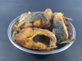 Tasty and spicy fish fry from Indian Food. Tasty baked fish on plate isolated on black background. best fish for frying india. fish fry masala. bengali fish fry recipe. It contains lots of vitamins.