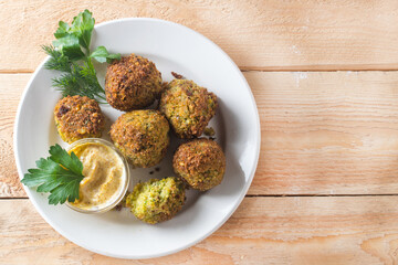 falafel with herbs and hummus on a white plate