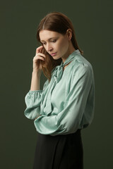 Fashion studio shot of woman in mint green silk satin blouse