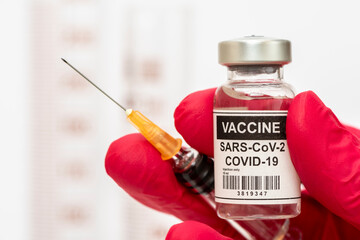 Impfung mit Ampulle und Impfstoff gegen Coronavirus COVID-19