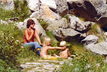 Vintage colorful 1977 image of a young mother with son and daughter having a picnic on the Monte...