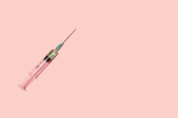 Syringe on pastel pink background.(Coronavirus vaccine) Copy Space
