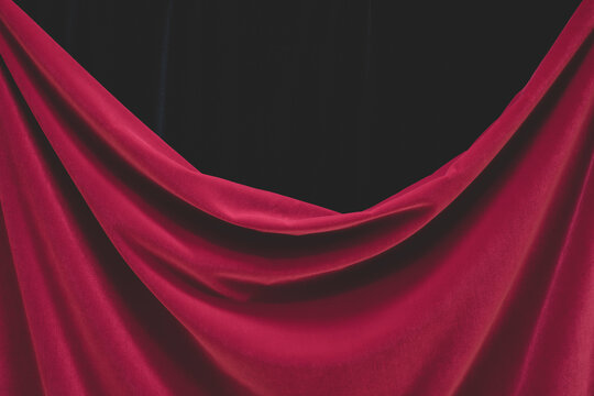 Detail of draped red velvet curtain with folds and creases