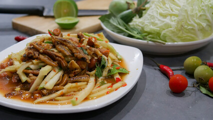 Yum, mango photo top views Food arrangement. Spicy salad food, topped with fried nuts and crispy fish. The main ingredients are raw mango, lime juice, fresh chili powder, fish sauce, sugar to mix.