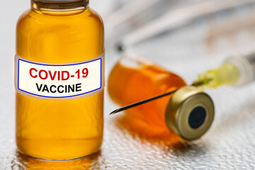Impfung mit Ampulle und Impfstoff gegen Coronavirus COVID-19