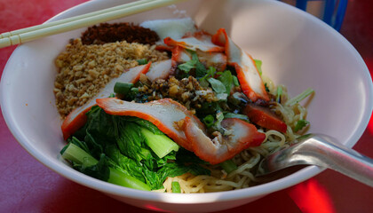 Dry red pork noodles. Yellow Noodles and Boiled Vegetables Topping with Roasted Pork. Famous Street Food in Thailand.