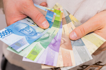The currency of Indonesia, Rupiah, File of banknotes held in the hand