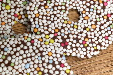 Nahaufnahme von kleinen runden geschichteten Schokoladen-Teilchen, die mit vielen bunten und weißen Zuckerperlen bestreut sind