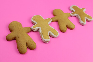 gingerbread men in a row on a pink background