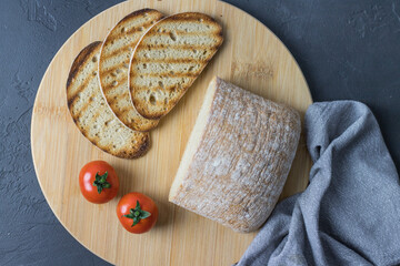 Grilled slices of bread lying on a wooden kitchen board top view
