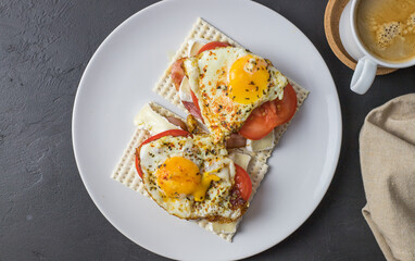 Diet bread sandwiches with egg and juicy tomato on a white plate. View from above.