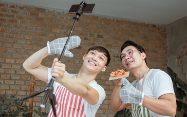 Two male bloggers online streaming video clip of cooking in the kitchen