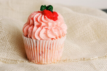 Pink decorative icing on cupcake for dessert food close up.