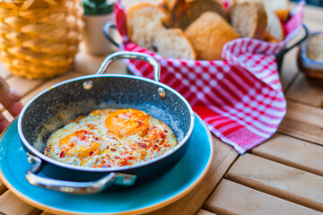 Fried Eggs dressed. Breakfast sunny side up eggs with seasoning on copper pan