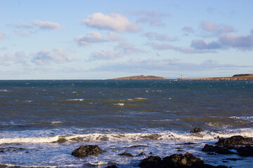 Fototapeta na wymiar 24 December 2020 A view of the rough seas across the Copeland Sound towards the Copeland Islands an a bright winter afternoon. The Mew Island Lighthouse is located on in the sound close to the Irish 