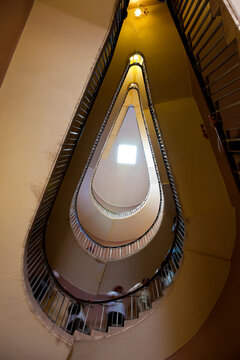 People ascending a spiral stair, view from below. 