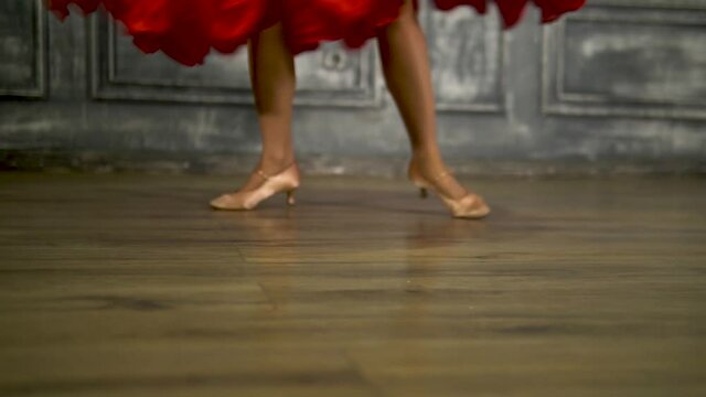 The dancer's legs in a red dress. Spinning, waltzing
