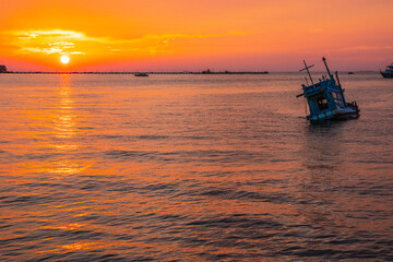 an old ship during the sunset on the sea in the Gulf of Thailand